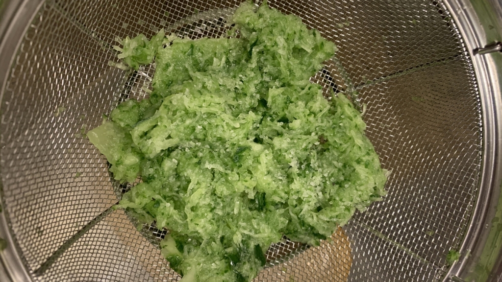 English cucumber grated, draining in mesh strainer.